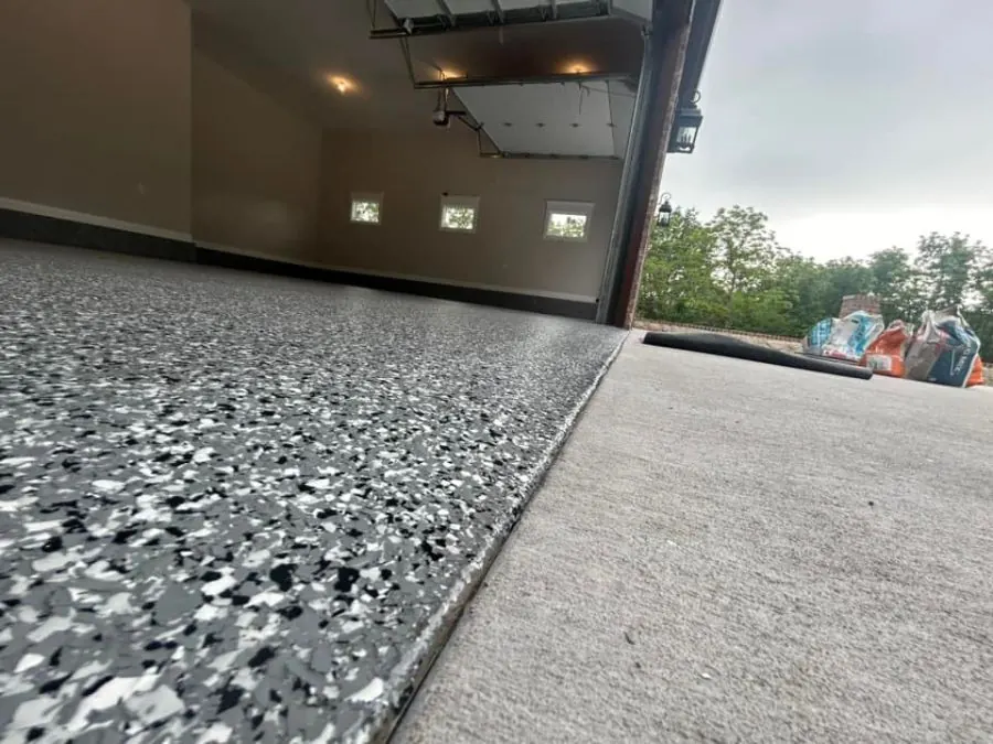 Red, black, and white flake epoxy garage floor coating with garage door open in Springfield, MO