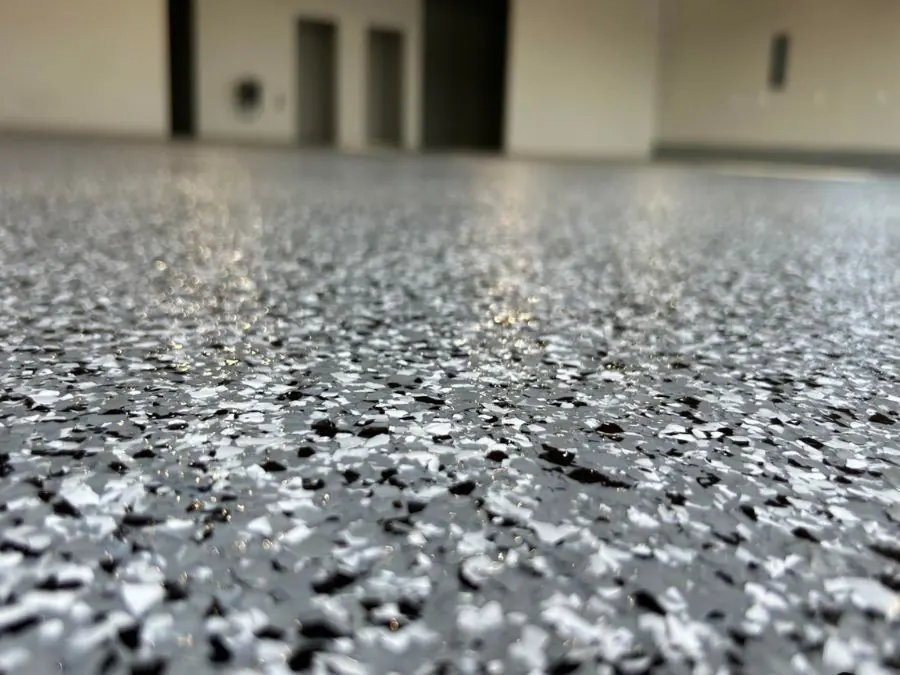Grey flake epoxy garage floor coating along a concrete driveway edge in Springfield, MO
